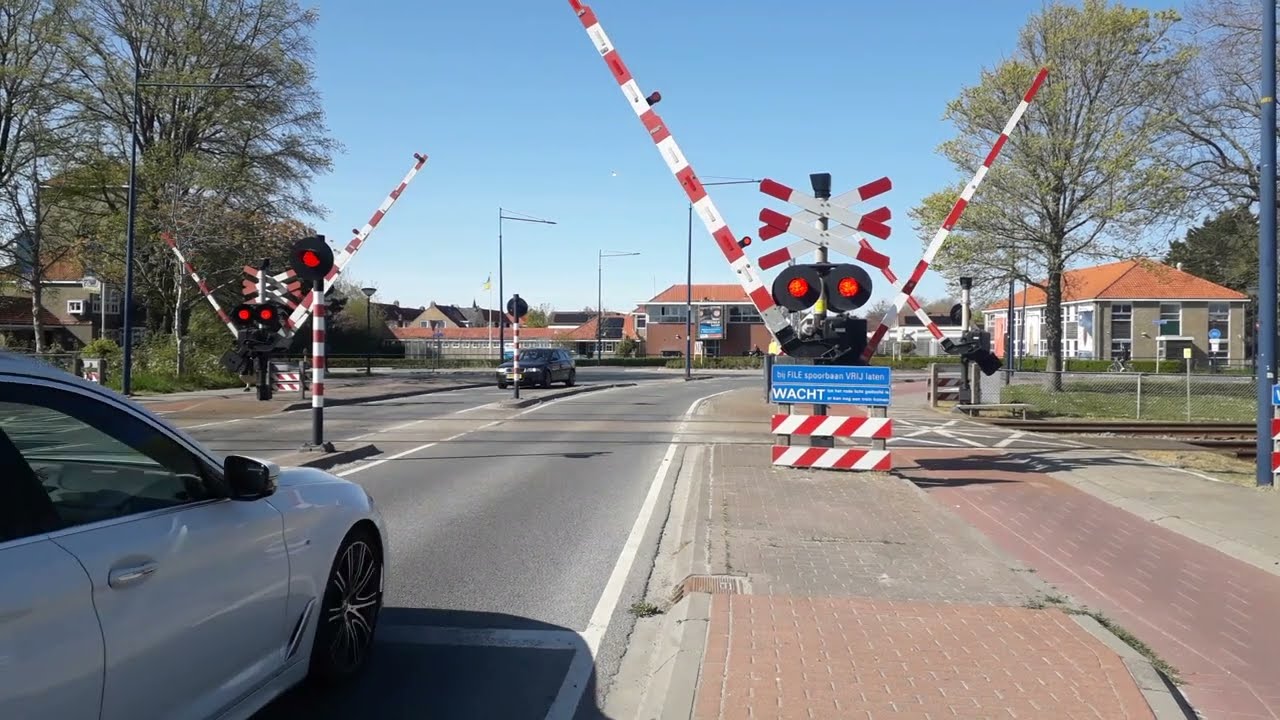 LEVENSGEVAARLIJK! Kinderen steken overweg over, de spoorbomen zijn al bezig met sluiten!