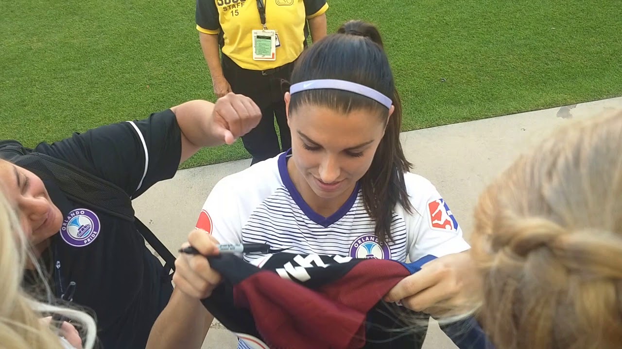 Alex Morgan switches head band with girl