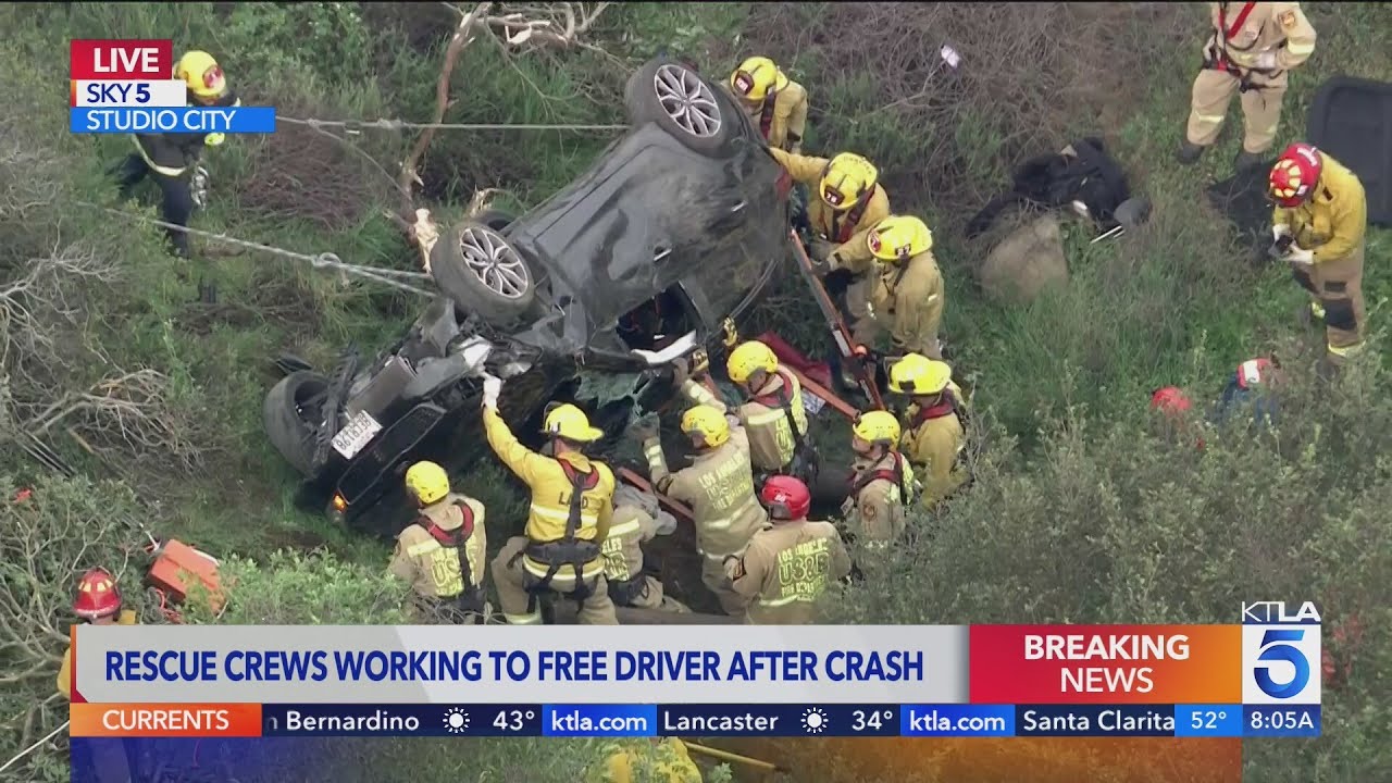 Rescue crews work to free driver after crash off Mulholland Drive