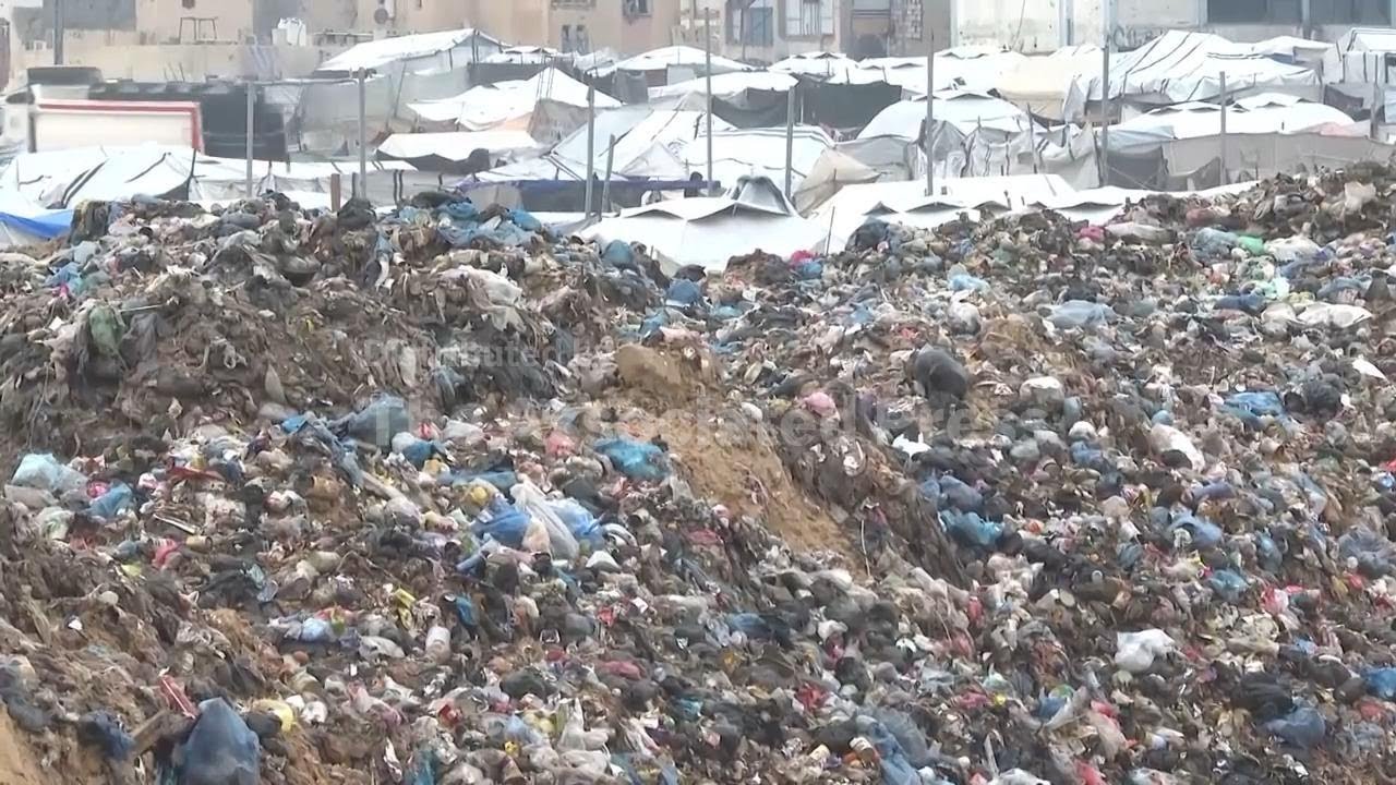 Palestinians exposed to harsh winter weather search through rubbish to find items to keep warm