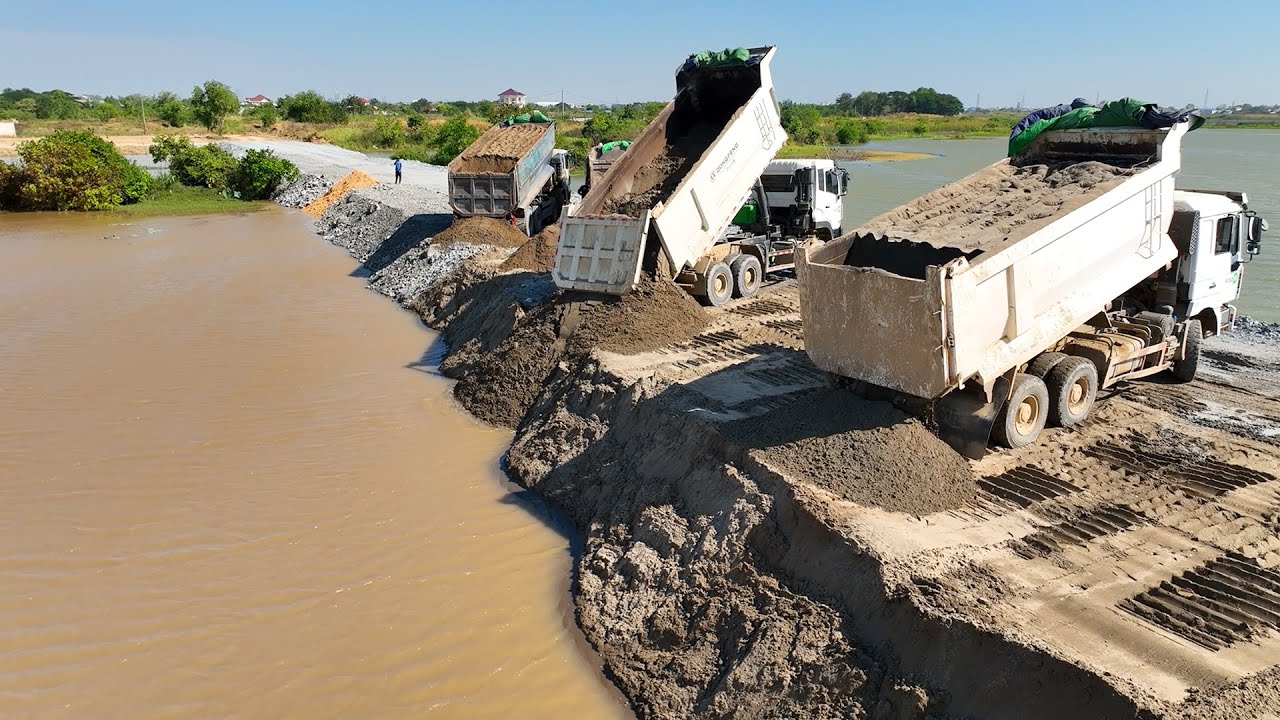 Sand is poured into the lake with a SHANTUI bulldozer, pushing it skillfully.