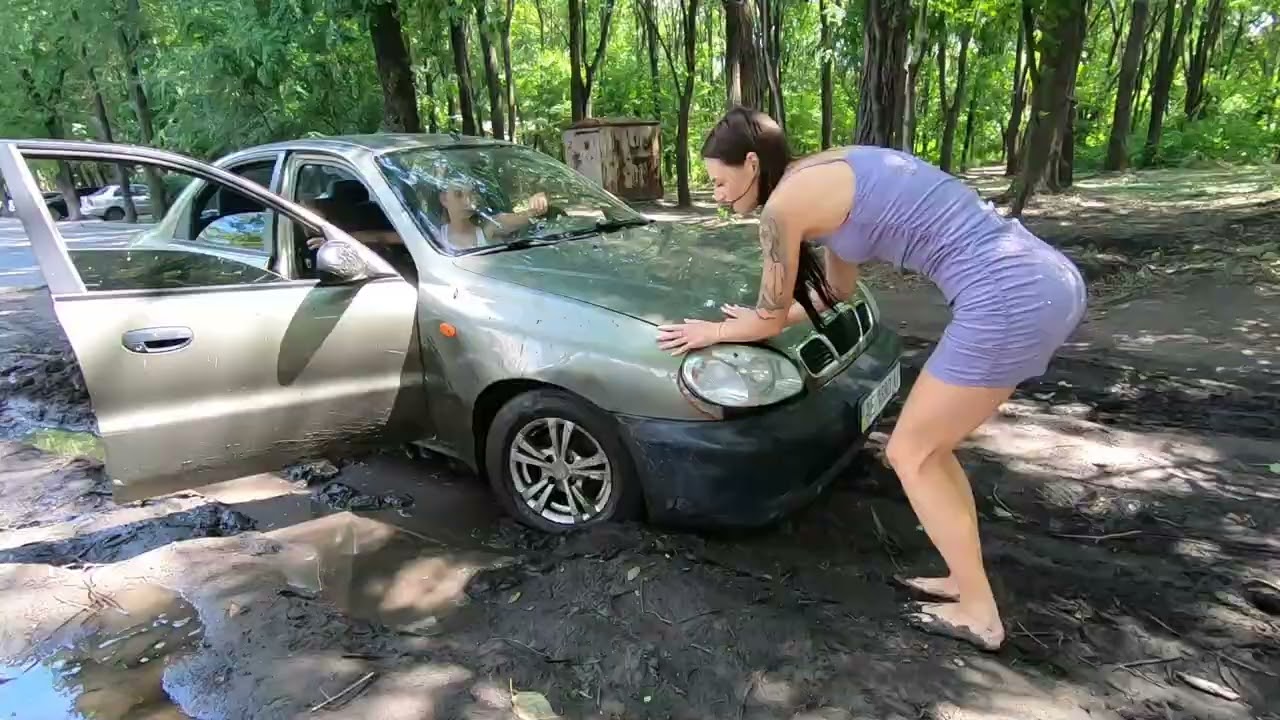 Two girls getting stuck and pushing the car barefoot