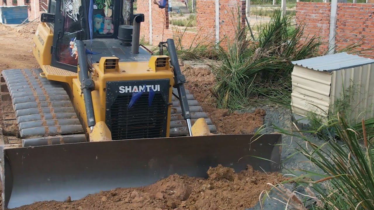 Excavator and Shantui Bulldozer Busy Working on Road Construction with Dump Trucks