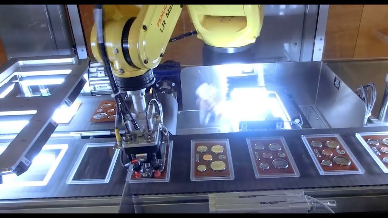 Роботизированная система сборки наборов монет использует 13 роботов FANUC для сборки наборов моне...