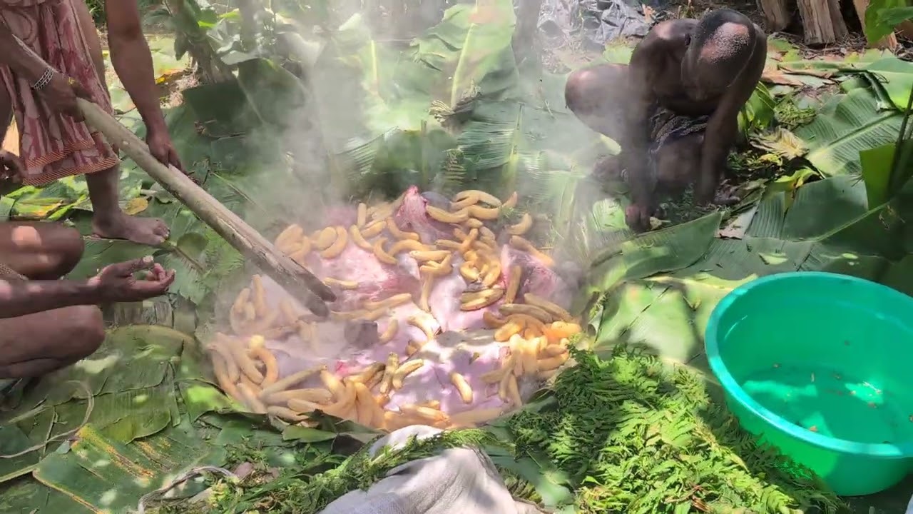 Приготовление мяса под землей на раскаленных камнях в банановых листьях