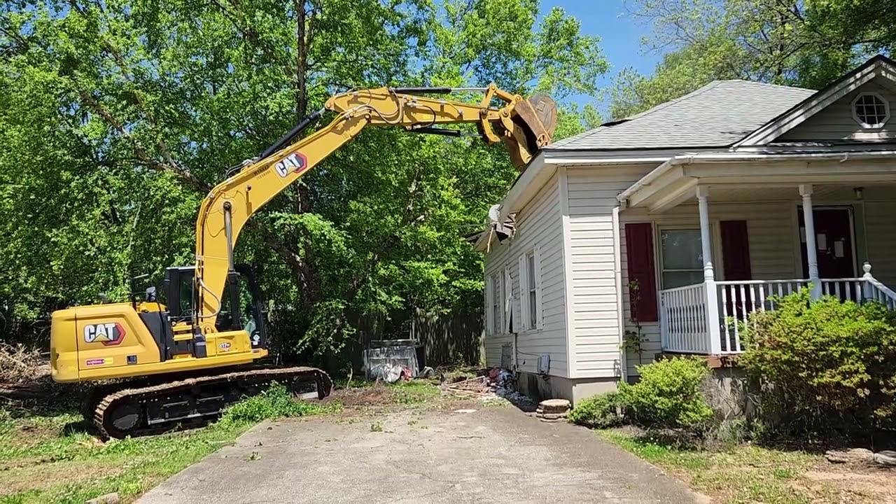 Cat 317GC demolishes a house