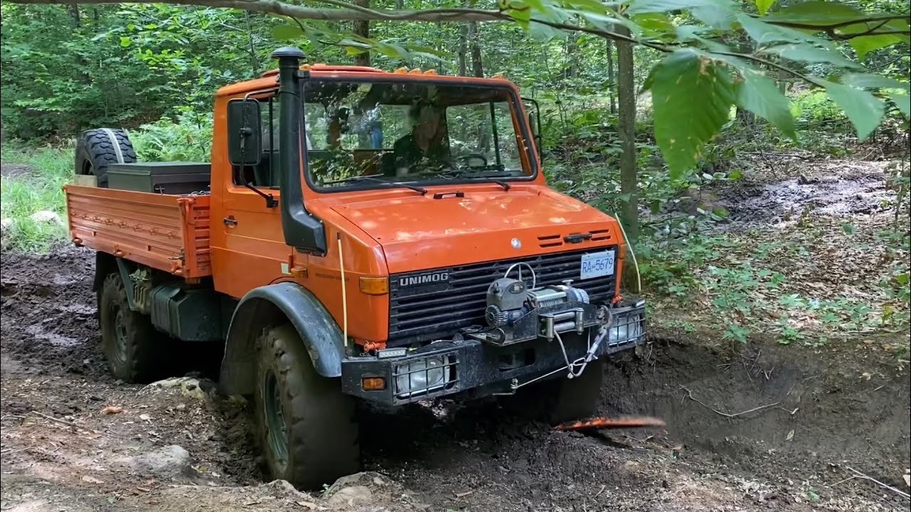 Orange Unimog sorta stuck in shallow mud