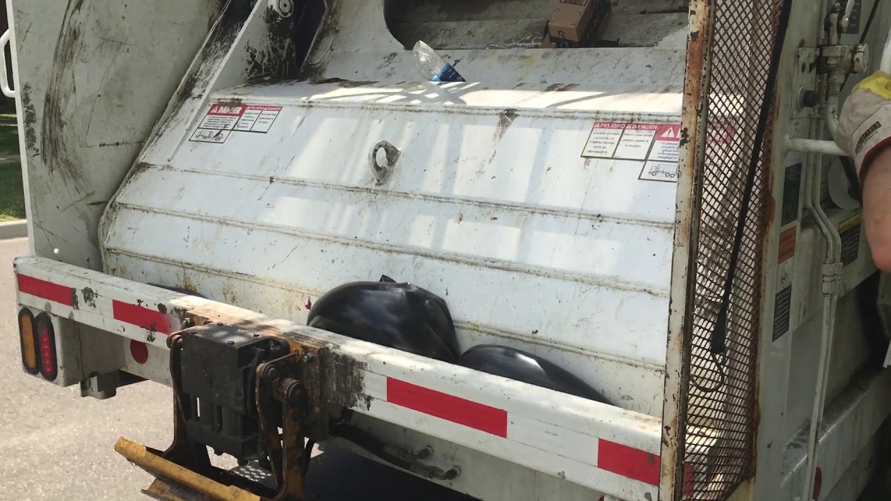 Rear load garbage truck crushing