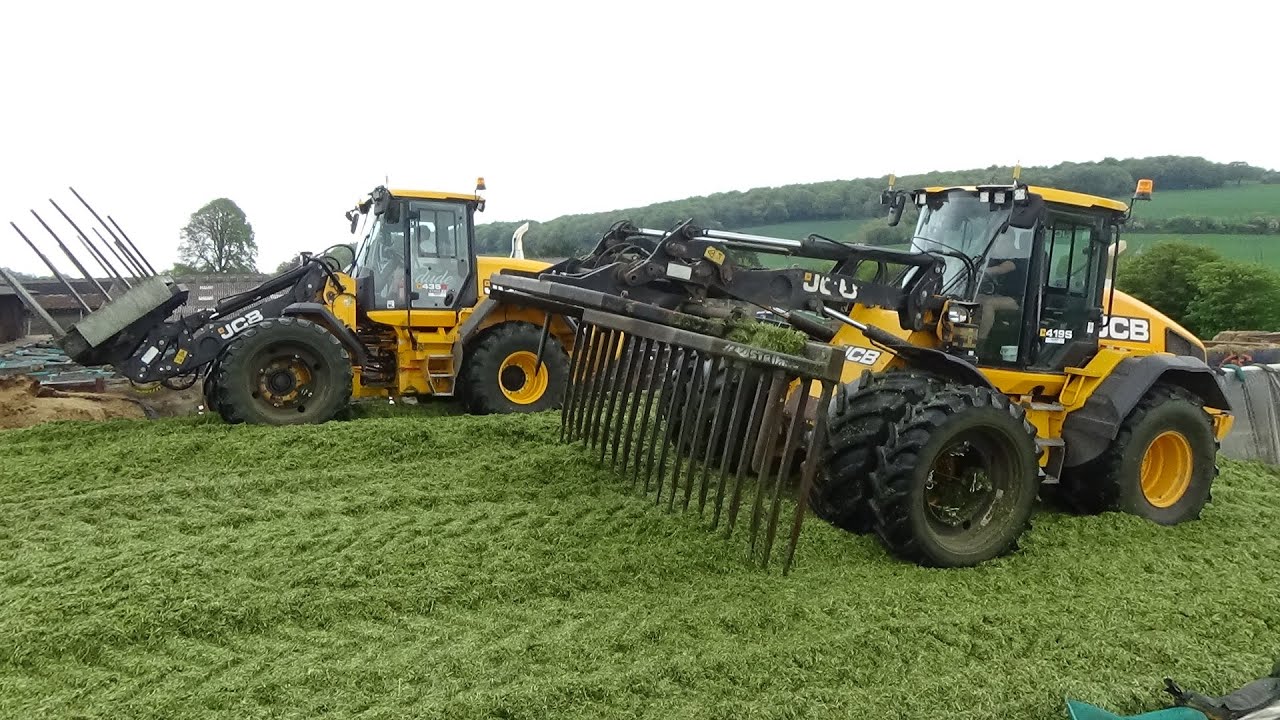 Silage 2021 - Buckraking the clamp with TWO JCBs plus New Hollands unload