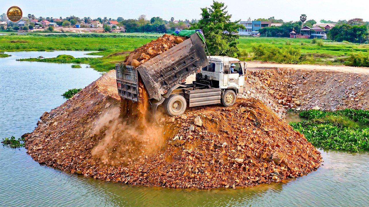 A new project! Complete 100%, Landfill by Komatsu-D20 Dozer pushing stone & 5-ton truck unloading.