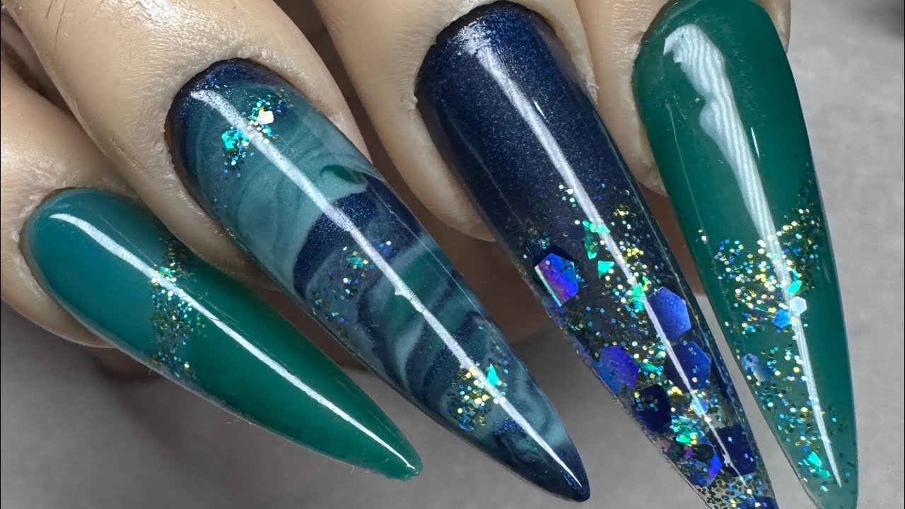 I’m back!!! Greens and blues acrylic nails with marble accent nail and a dash of glitter