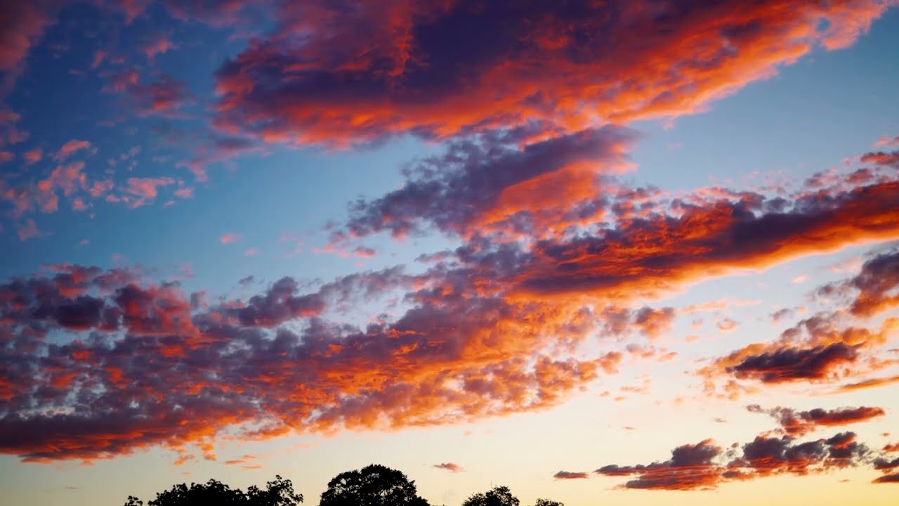 Partly cloudy pink and blue sunset timelapse