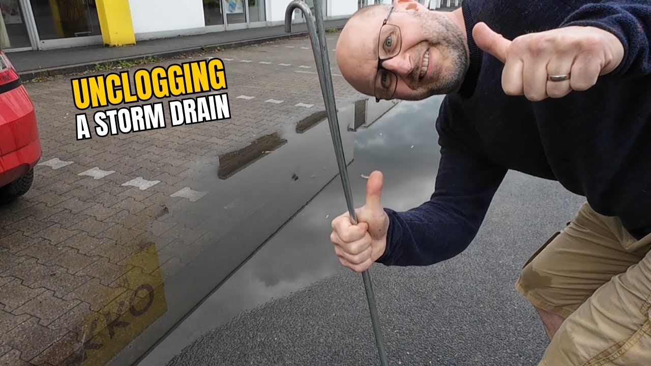 #067-1 Unclogging a storm drain on a parking space after rain in Germany