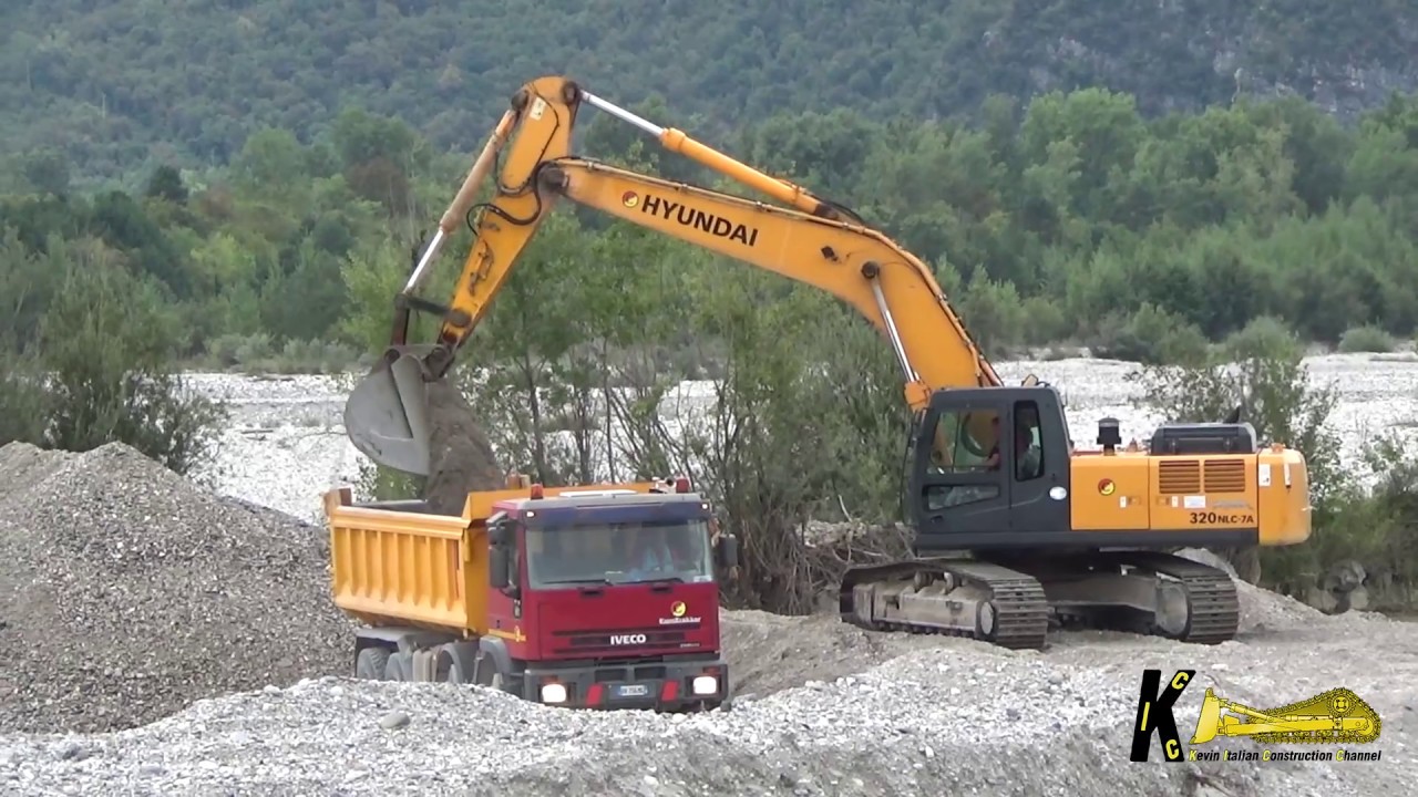 Hyundai 320 NLC 7A Excavator Loading Gravel on Some Truck's in the River