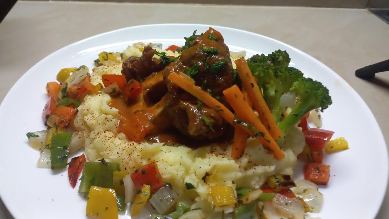Osso bucco en su salsa,  carne guisada con  pure vegetales,