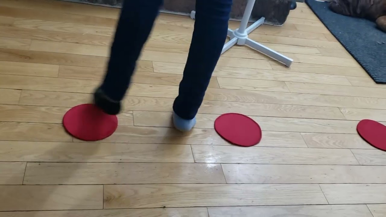 A girl training with ASZORTID Target Shots or Mini Discs in a walking side shuffle drill motion