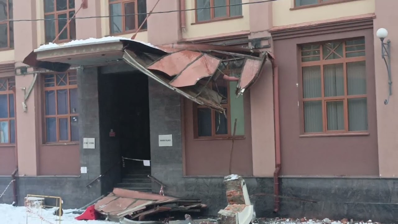 Москва . Снег с крыши поломал козырек, падение кирпича с крыши здания.