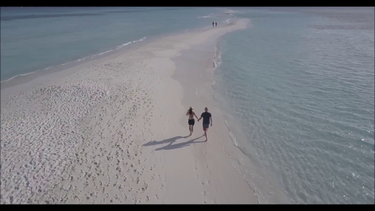 Couple Walking on a Beach captured by Drone | Aerial Shot Of Mountain And Ocean