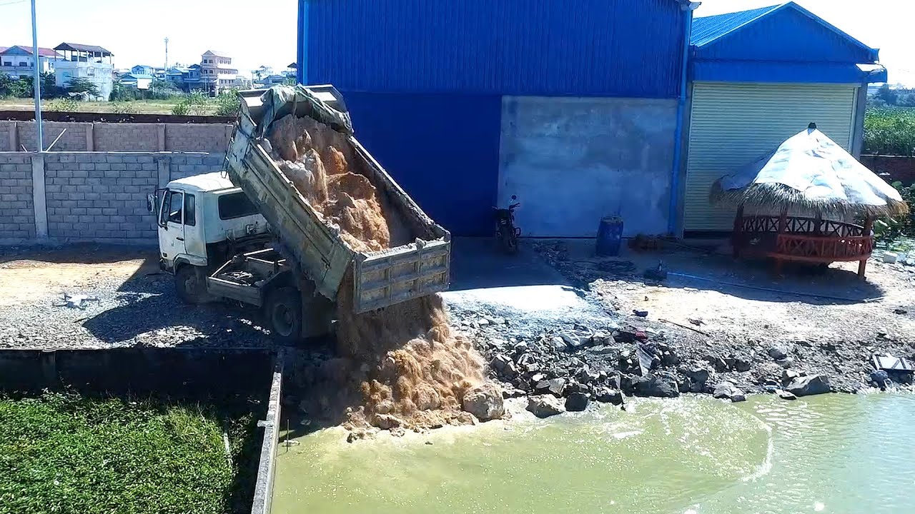 The activity of pouring soil into flooded areas to level the road for easier house building