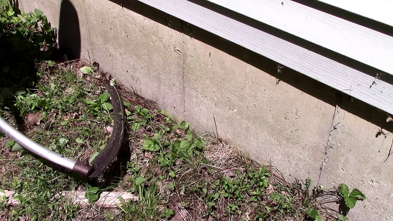 Scythe Trimming a Foundation
