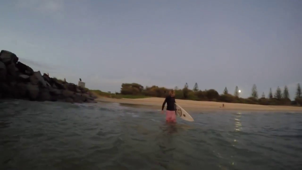 Surfing full moon just before the sun.