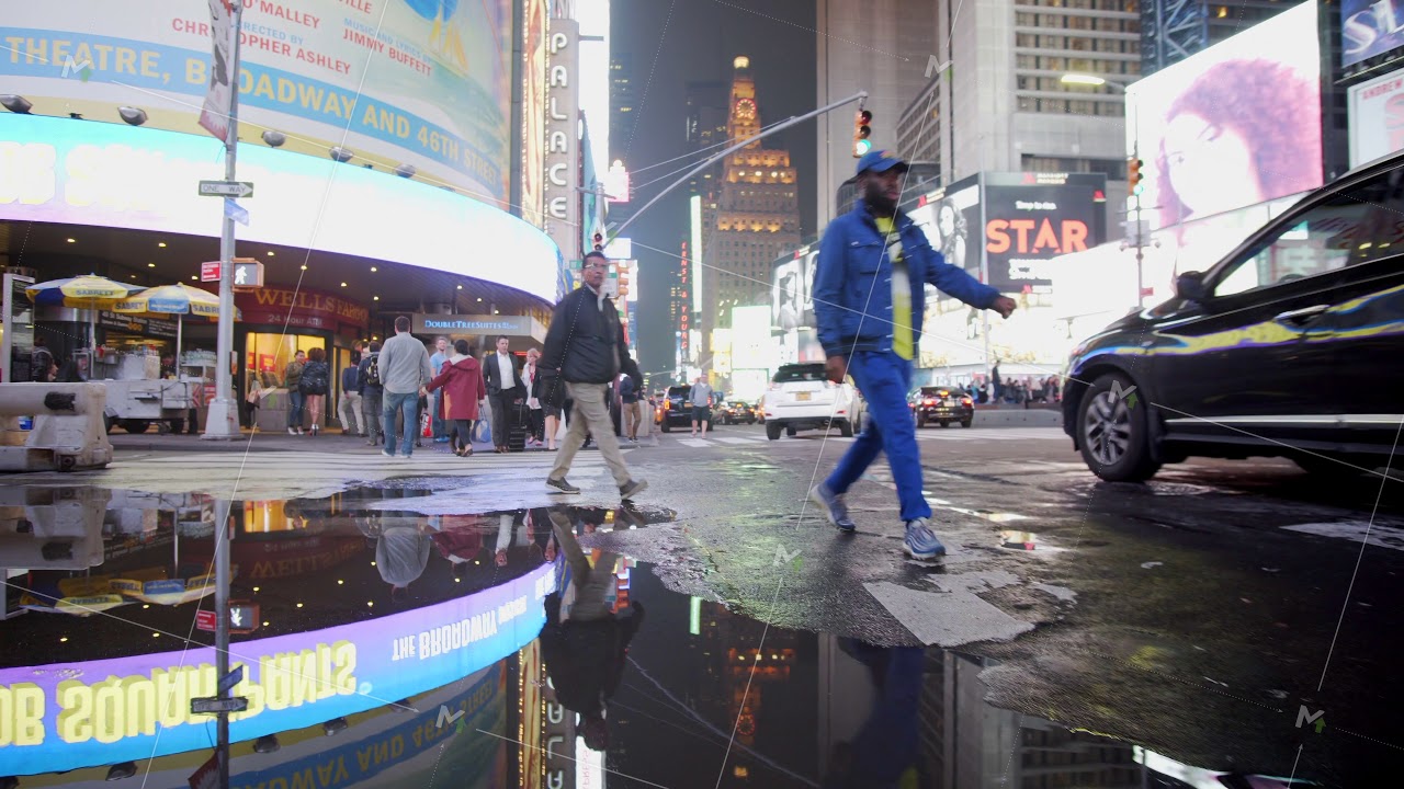 Times Square Lights reflecting in puddle after rain in New York City at Night Manhattan