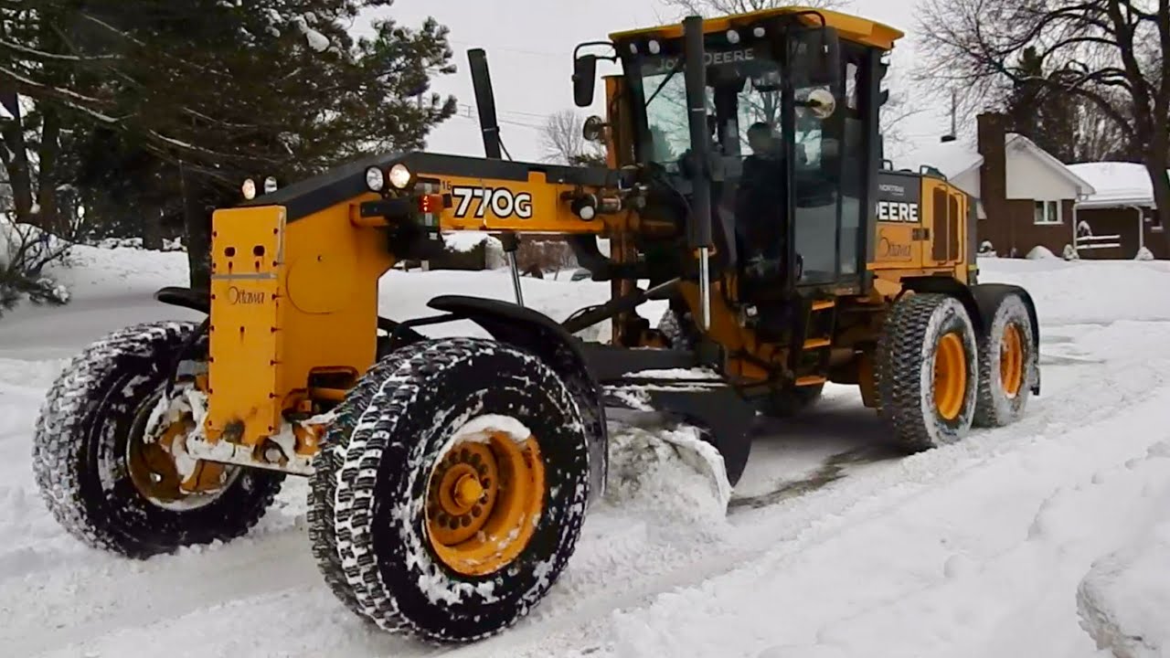 Snow Removal Grader Plowing Heavy Snow opening up road