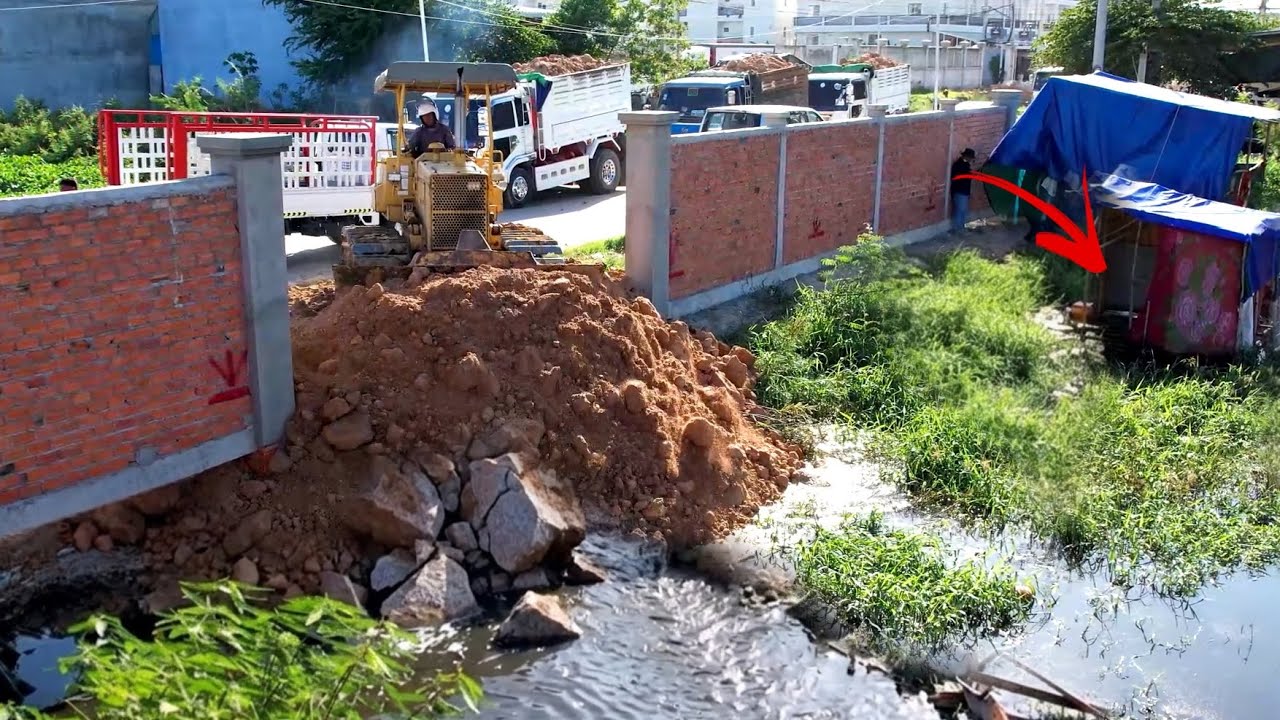Great work !! operator Bulldozer working push stone landfill flooded & team dump truck unloading 