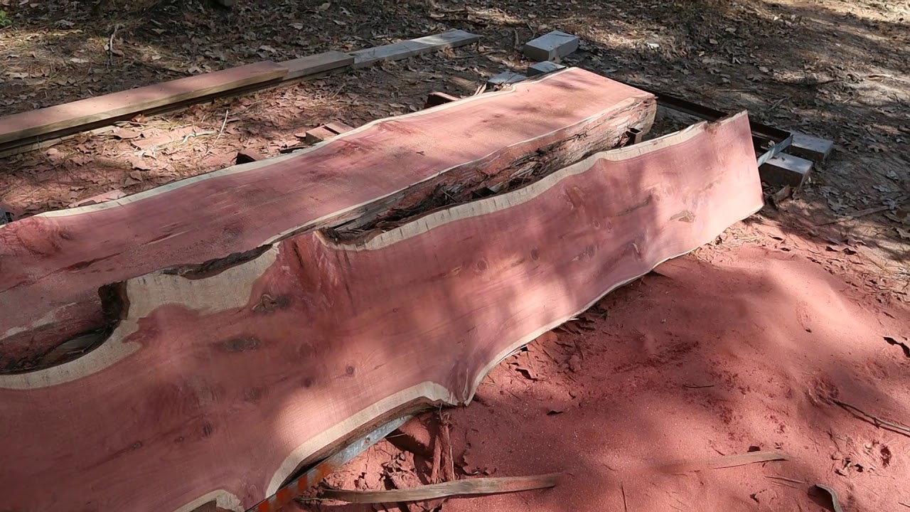 Cutting redwood cedar logs into slabs with homemade sawmill