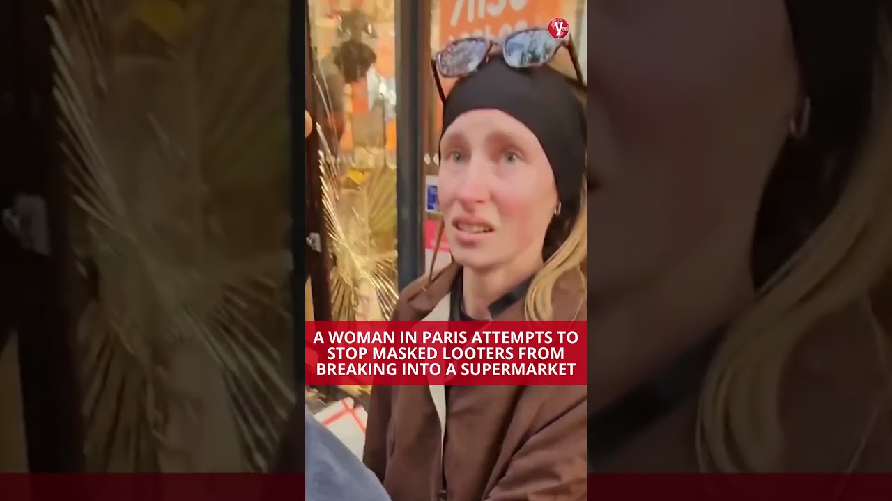 A woman in Paris attempts to stop masked looters from breaking into a supermarket
