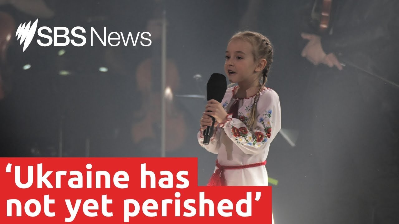Seven-year-old girl sings Ukrainian national anthem in moving charity event performance | SBS News