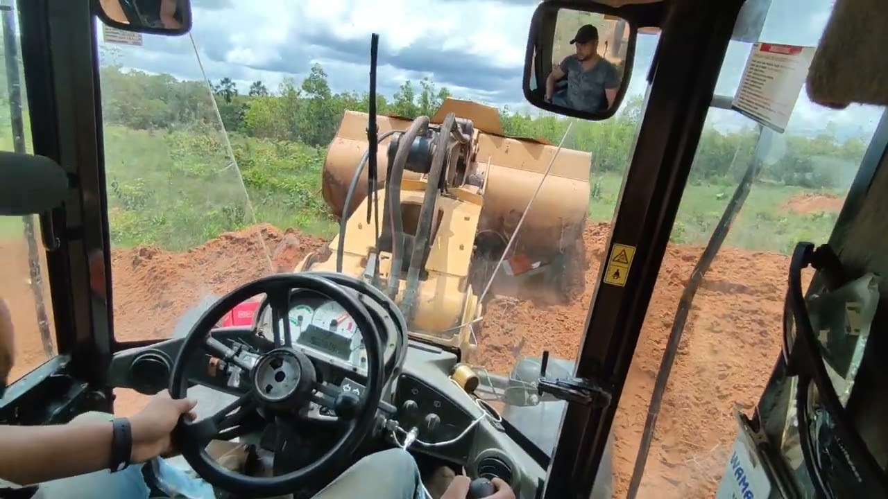 Pá carregadeira.       Fazendo caixa de contenção ou bacia com lombada para tira água da estrada