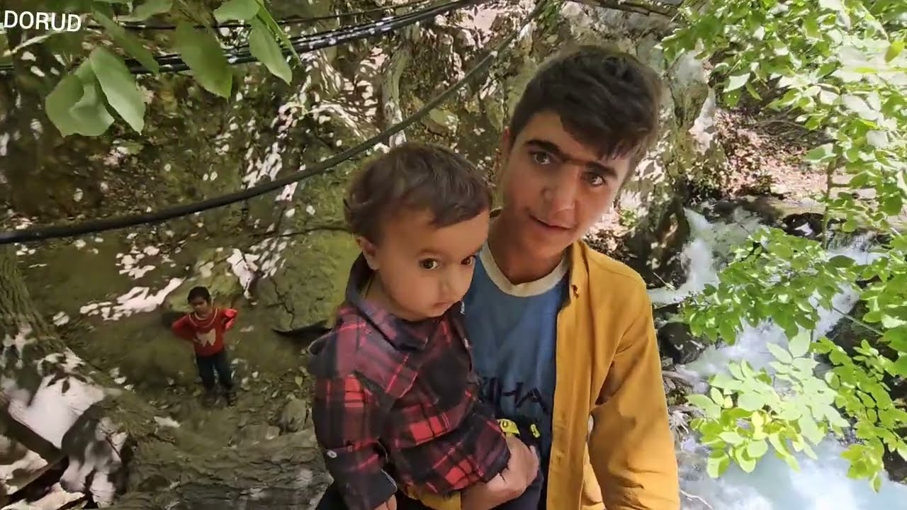 Rock climbing of Akram and his children in a large waterfall