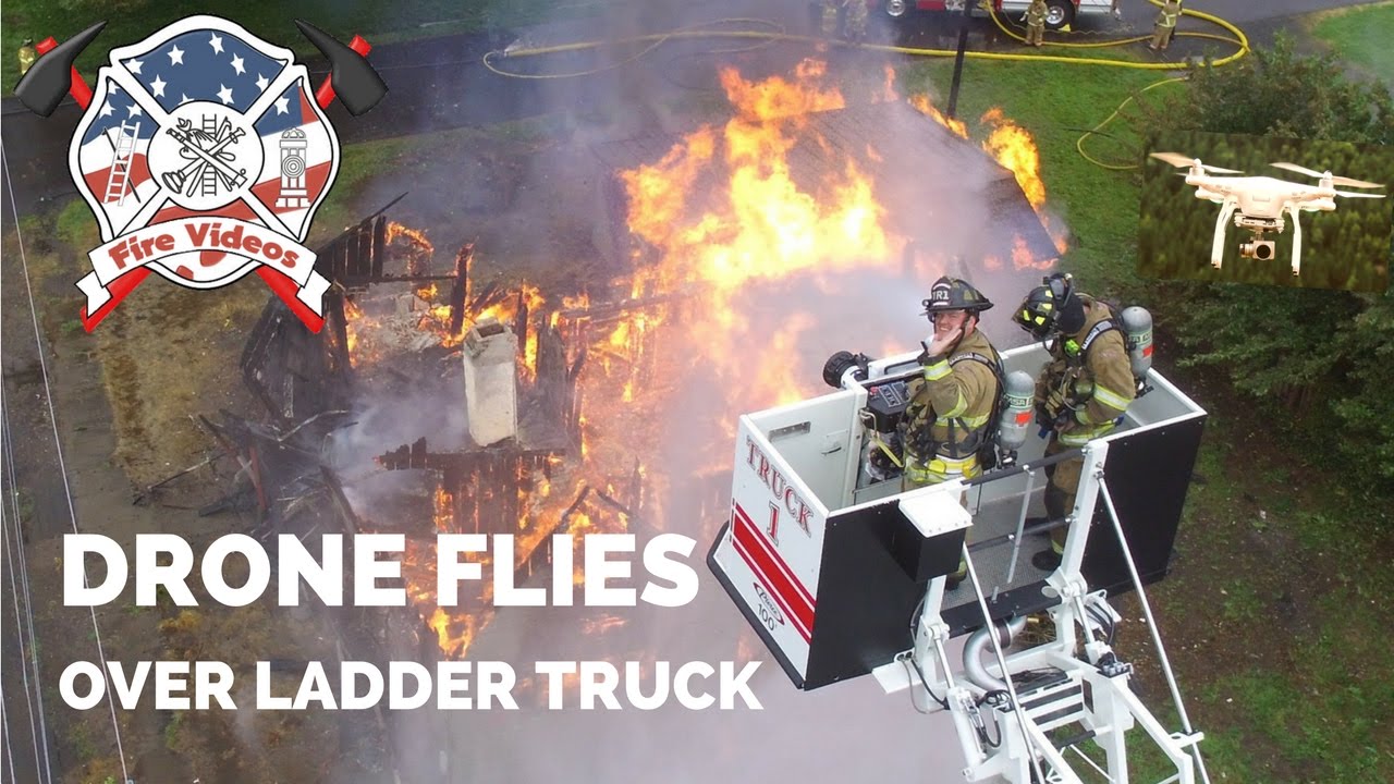 Phantom drone flies over a ladder truck at a flashover house fire