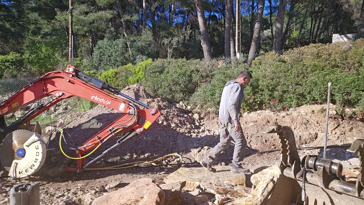 Coupe d une pierre avec une scie hydraulique sur mini pelle