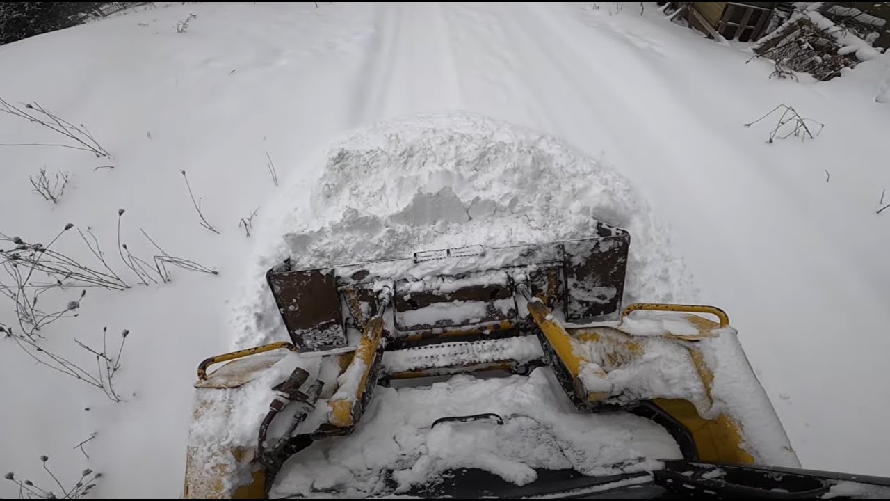 Beginner skid steer operator on icy driveway