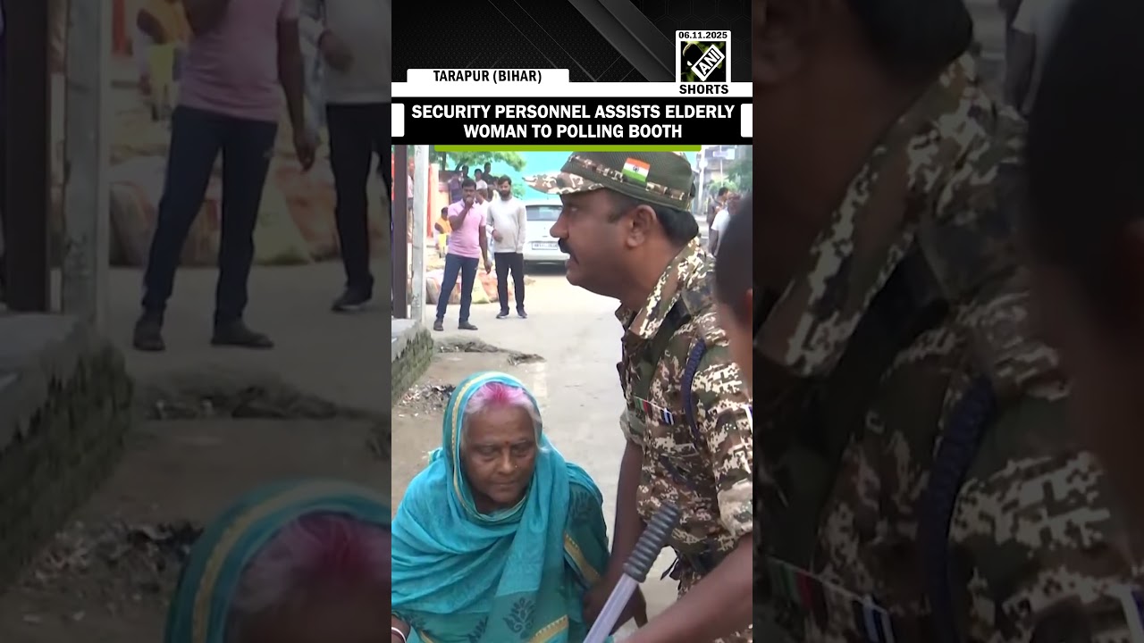 Security personnel assists elderly woman to polling booth during first phase of assembly elections
