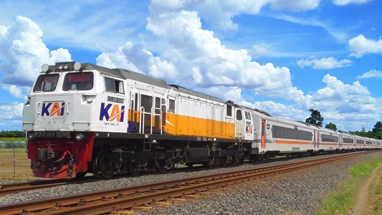 Kereta Api Panjang Lokomotif CC206 CC201 Melaju Cepat Melewati Perlintasan Jembatan