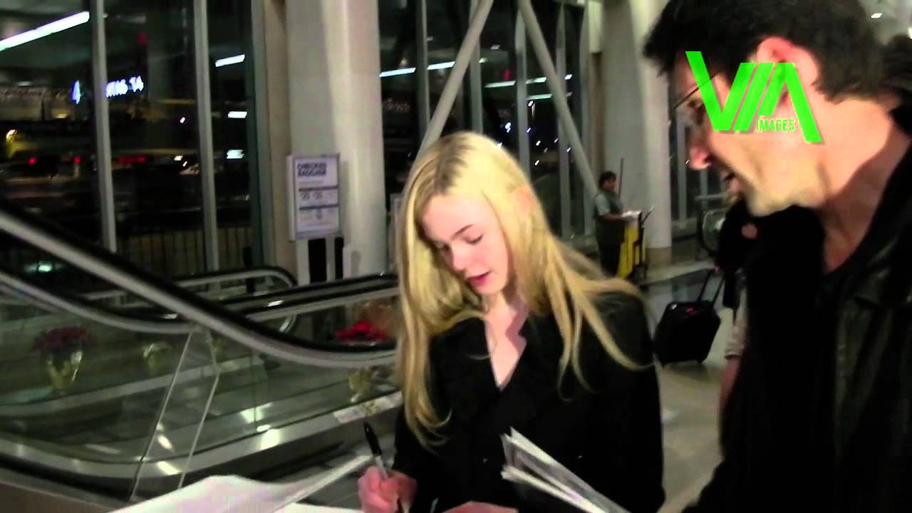 Elle Fanning signs endless autographs at LAX! - Via Images