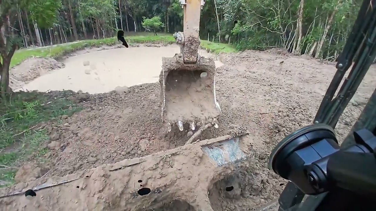 Escavadeira hidráulica no acabamento de tanque 