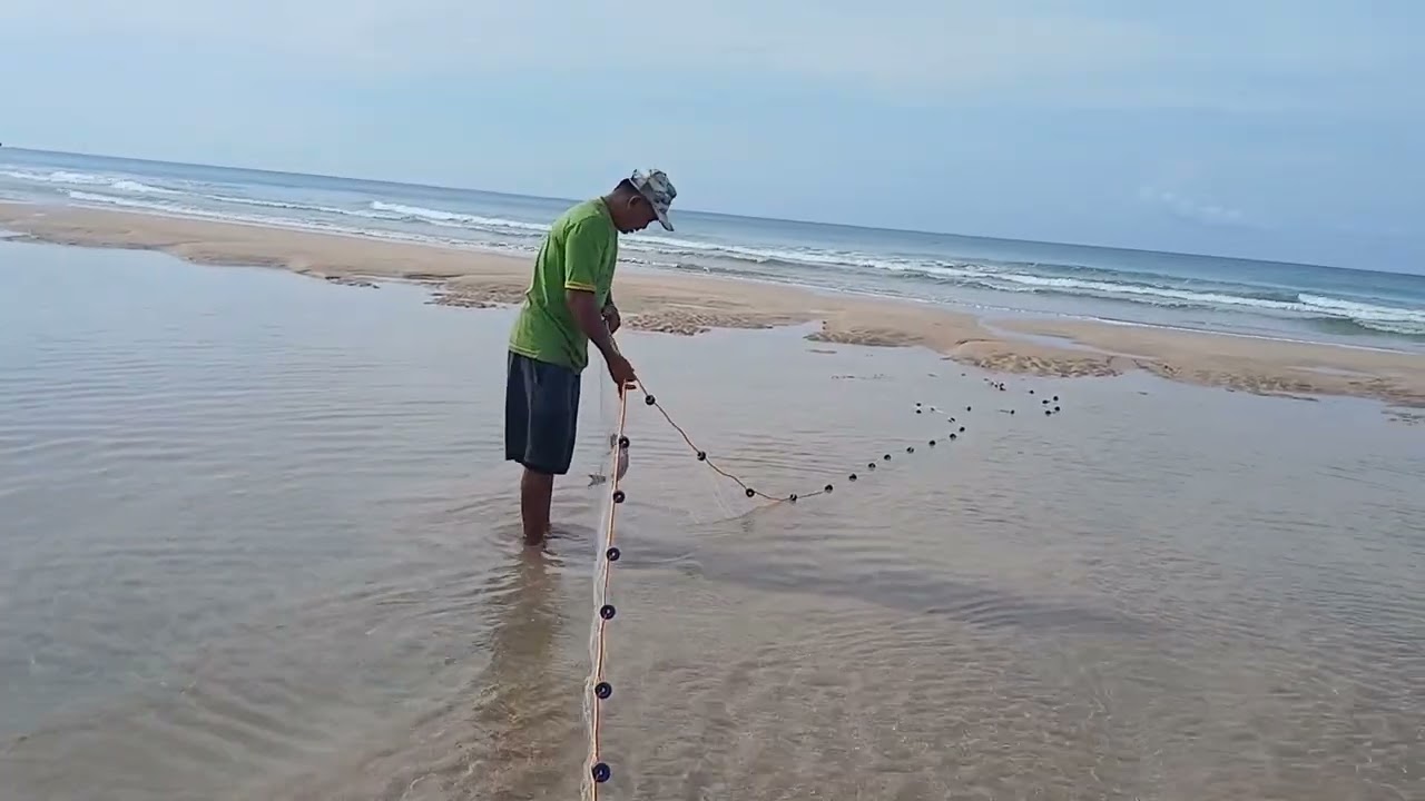 Menjaring ikan di kolam dangkal yang terbentuk akibat air laut surut di Pulau Adijaya, Papua Barat.