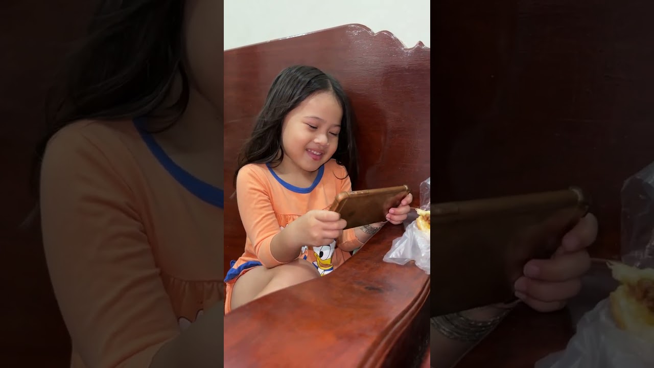 Sethika and Vitou are eating bread and playing game together