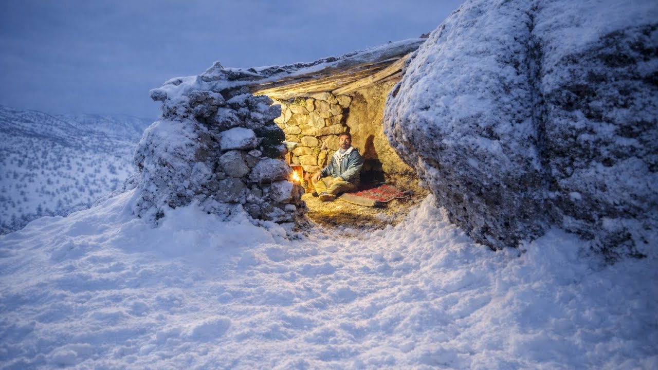 Building a stone survival shelter with fireplace .one peaceful night in winter storm