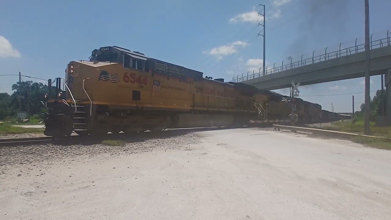 UP AC4400CWM 6544 leads a northbound gravel train through McNeil plant with a Capmetro train