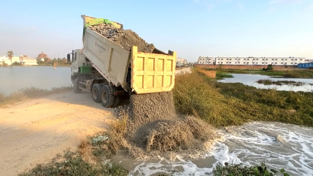 Nicely !!  dump truck wheel 10 unloading soil landfill flooded area with SHANTUI dozer working push 
