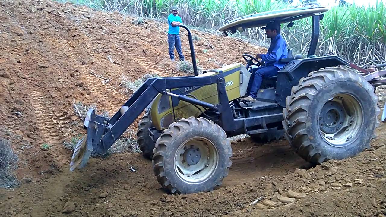 Trator Valtra trabalhando com lâmina e arado