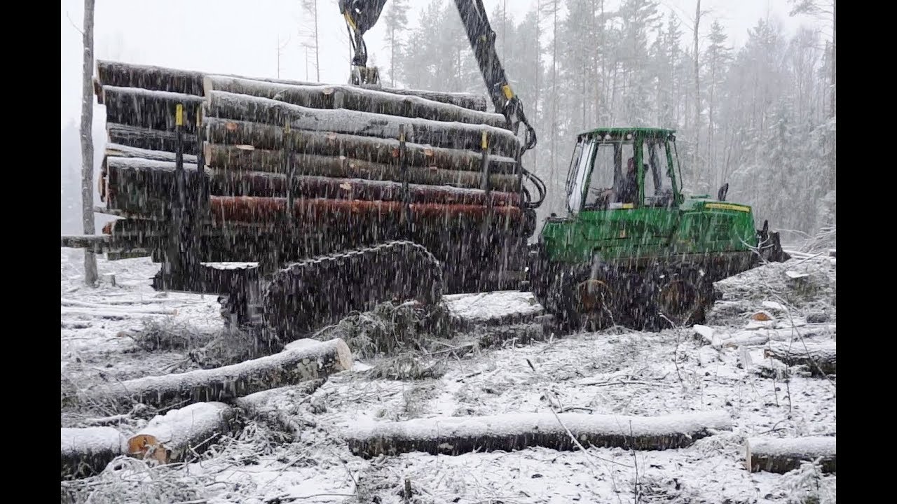 John Deere 1110E logging in snowy forest, big load, skilled operator