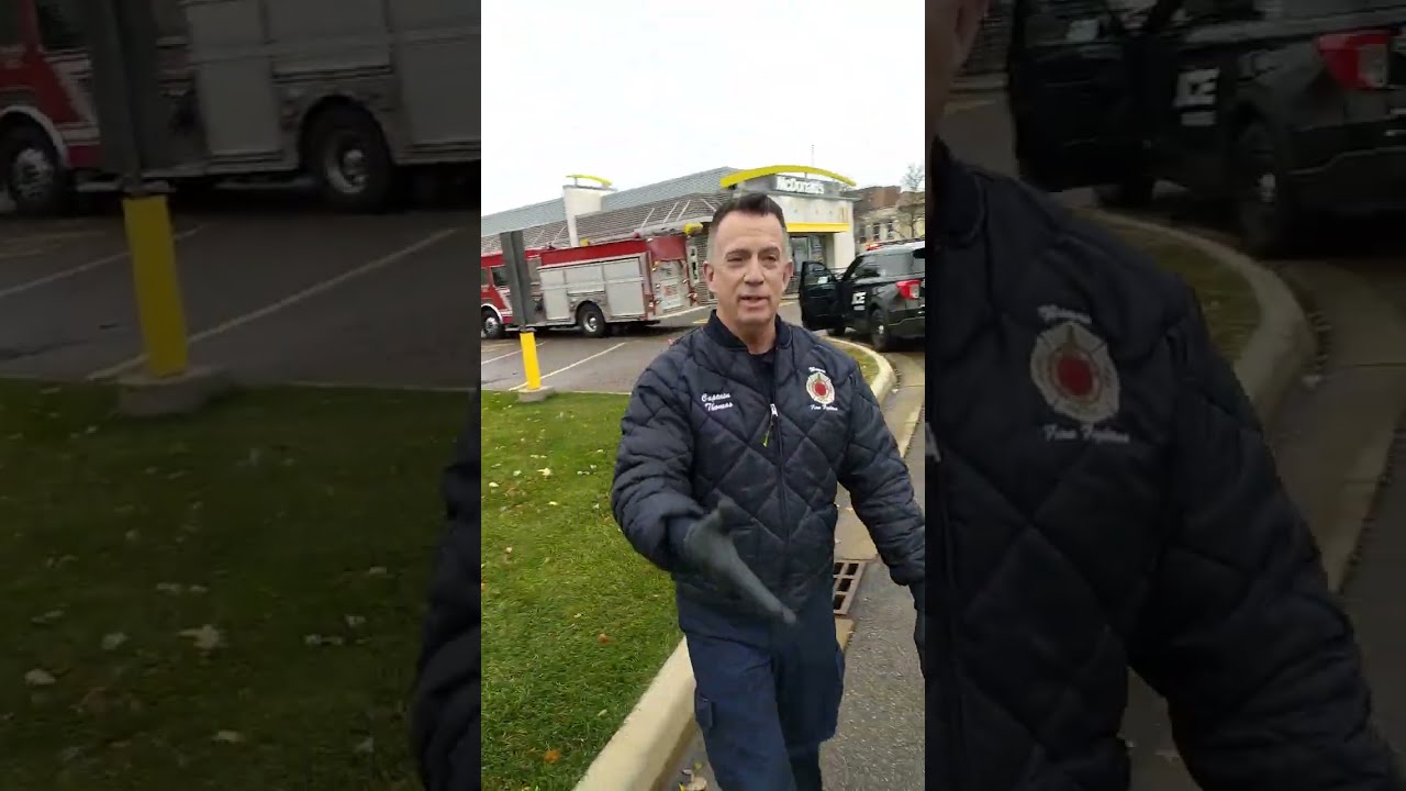 Firefighters and cops standing over a man