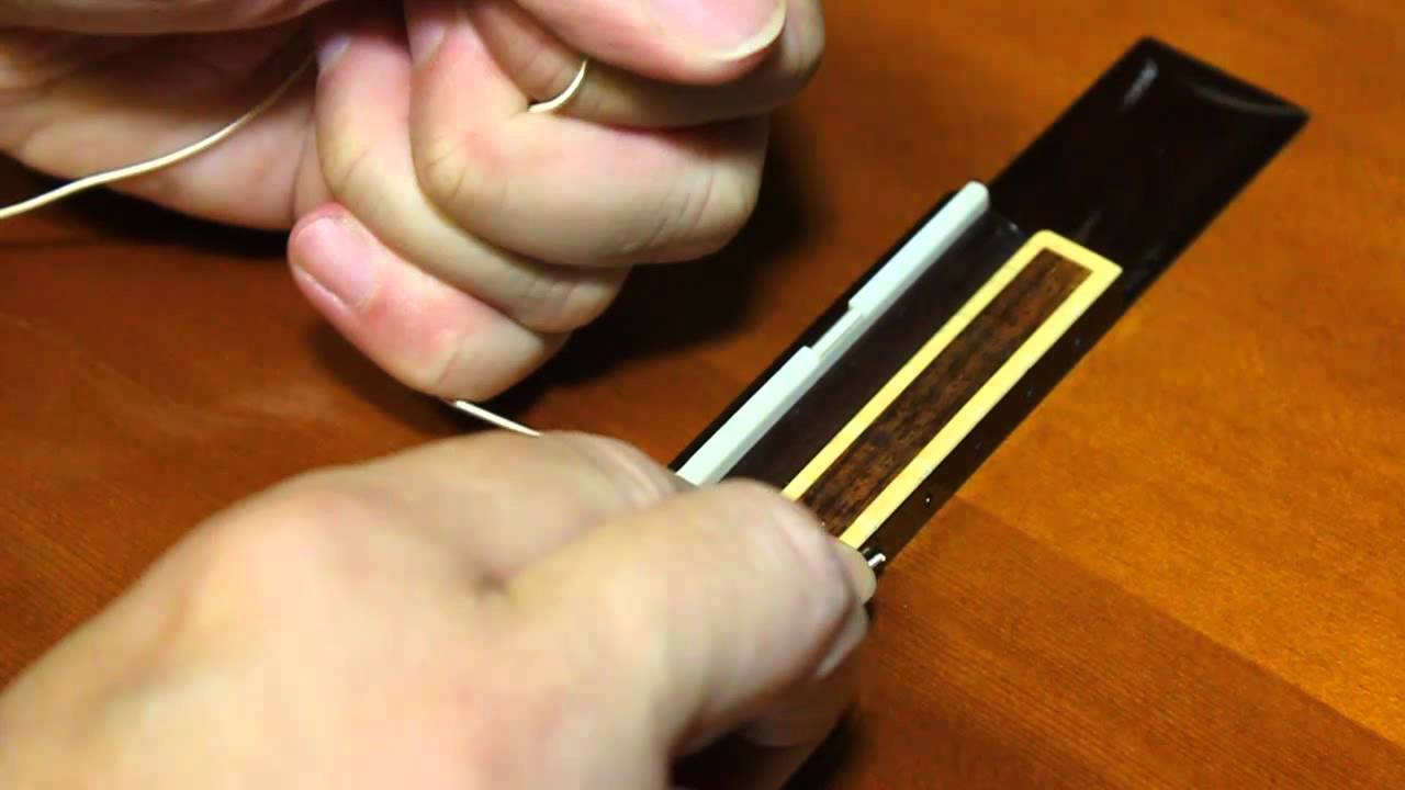 Changing guitar strings on a classical, nylon string guitar, or replacing a broken string