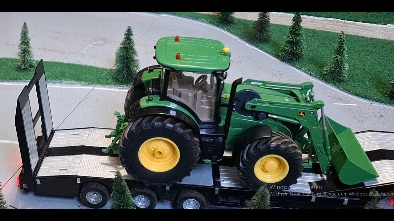 Siku Control John Deere 7310R wird auf Volvo FH 16 antransportiert.